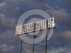 Stadium-style lights against a cloudy sky