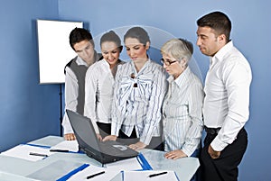 Staff of business people in office using laptop