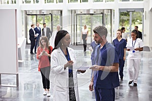 Staff In Busy Lobby Area Of Modern Hospital