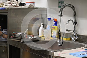 staff cleaning professional cook appliances and ware in professional kitchen