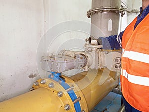 The staff dressed in an orange warning vest check the knife valve