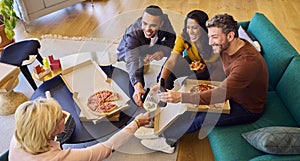 Staff At Informal Meeting In Office With Takeaway Pizza And Drinks