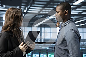 IT staff members in data center using tablet, verifying rigs photo