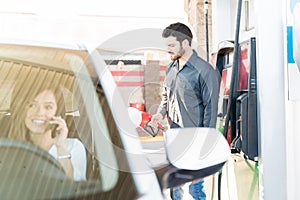 Staff Refueling Car At Gas Station