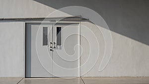 Staff room door with pipelines on grey cement wall background