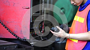 Staff or technicians are checking the operation of the old machine via the remote control. Professional technicians are controlli