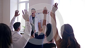 Staff training, successful people raise hands up to share thought with coach and audience on seminar