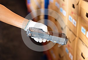 Staff wearing white gloves holding a barcode reader. the product has a sticker using modern technology to read values. Makes