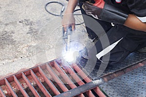 Staff welder is doing maintenance on the damaged cutter rails on the road