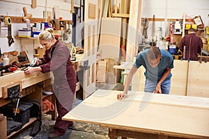 Staff Working In Busy Carpentry Workshop