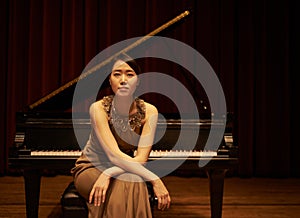 Stage, concert and portrait of Asian woman with piano for performance, entertainment and talent show. Musician, creative