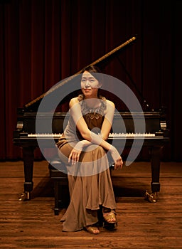 Stage, concert and portrait of woman with piano for performance, entertainment and talent show. Musician, creative