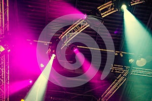 Stage lights on concert. Lighting equipment with multi-colored beams. Bottom view. Selective focus. Copy space