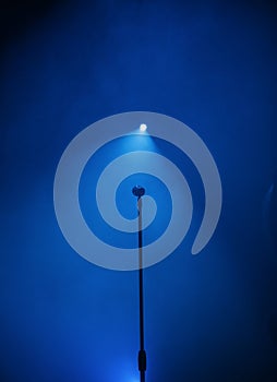 Stage with microphone and blue spotlight