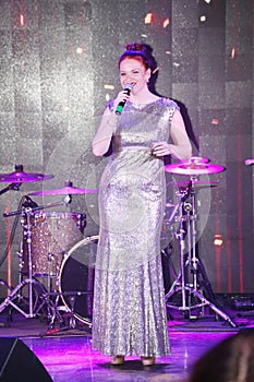 On stage, the musicians pop-rock group Spearmint and singer Anna Malysheva. Red headed Glam Rock Girl singing.