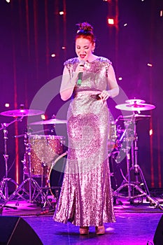 On stage, the musicians pop-rock group Spearmint and singer Anna Malysheva. Red headed Glam Rock Girl singing.