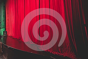 Stage with velvet red curtain in theater cinema, empty old-fashioned elegant theatre wooden stage with red cloth drapes curtains