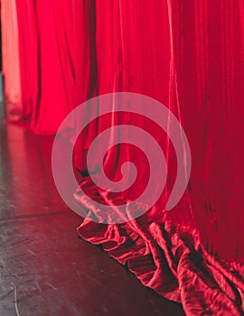 Stage with velvet red curtain in theater cinema, empty old-fashioned elegant theatre wooden stage with red cloth drapes curtains