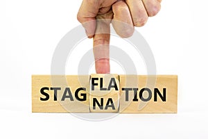 Stagflation or stagnation symbol. Businessman turns cubes, changes the word stagnation to stagflation. Beautiful white table,