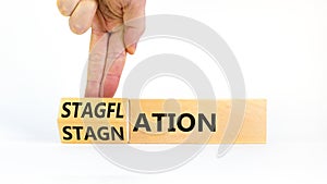 Stagflation or stagnation symbol. Businessman turns cubes, changes the word stagnation to stagflation. Beautiful white table white