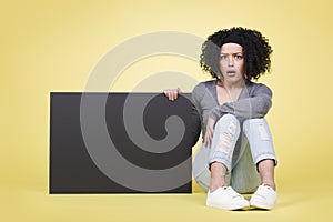 Staggered girl holding a black blank sign board with copyspace.