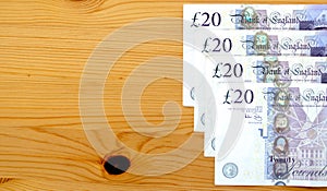 Row of British twenty pound notes on a table