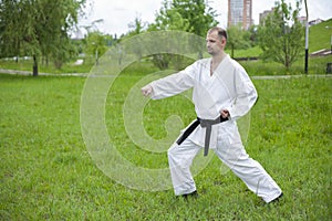 Staging. Black belt in karate. Karate trainer shows tricks.