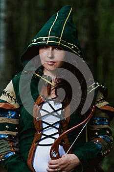 Staging photo of beautiful woman in fantasy suit with hood and bow