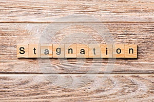 Stagnation word written on wood block. stagnation text on wooden table for your desing, concept