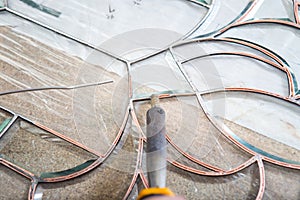 Stained glass maker works with souvenirs