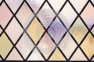 Stained glass with multi colored diamond pattern as background