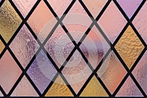 Stained glass with multi colored diamond pattern as background