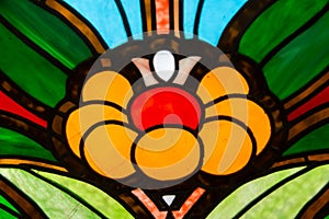 The stained glass window is bright and beautiful in the form of a yellow green blue flower. World tourism flowers