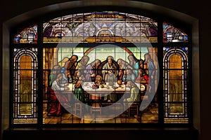 stained glass window depicting the last supper, with a view of individual pieces of mosaic art adorning the background