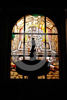 Stained glass window in front of the baptismal font in a religious building