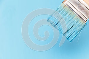 Staining the wooden surface with blue paint using a paint brush