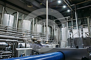 Stainless steel brewing equipment : large reservoirs or tanks and pipes in modern beer factory. Brewery production
