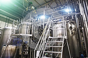 Stainless steel brewing equipment : large reservoirs or tanks and pipes in modern beer factory. Brewery production