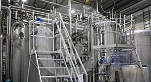 Stainless steel brewing equipment : large tanks and pipes in modern beer factory. Brewery production, industrial background