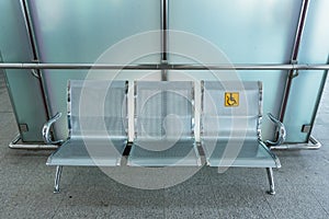 Stainless steel chairs in the train station with disabled signage to facilitate the use of train services for