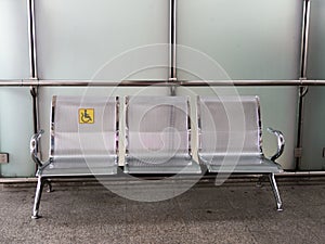 Stainless steel chairs in the train station with disabled signage to facilitate the use of train services for the disabled