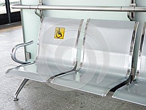 Stainless steel chairs in the train station with disabled signage to facilitate the use of train services for the disabled.