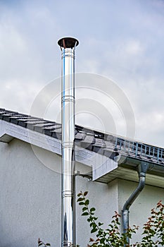 Stainless steel chimney and parts of a roof with solar panels and skylight