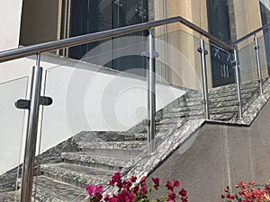 Stainless steel chrome plated finished hand rails with glass panels for an ramp or staircase steps for an building interiors for