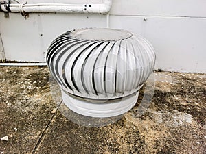 Stainless steel exhaust roof fan on the roof top spinning and take cool wind into the building on cement floor