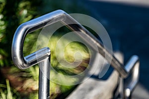 Stainless steel hand rail with grass in the background