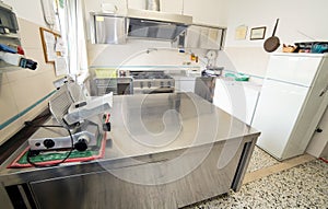 stainless steel kitchen with gas stove and an industrial meat slicer photo