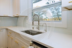 Stainless steel kitchen sink and window centered in a kitchen