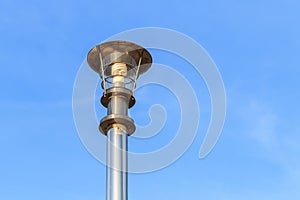 Stainless steel lamp pole at the road on blue sky