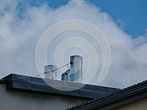 Stainless steel mechanical air vents on flat roof. blue sky and white cloud